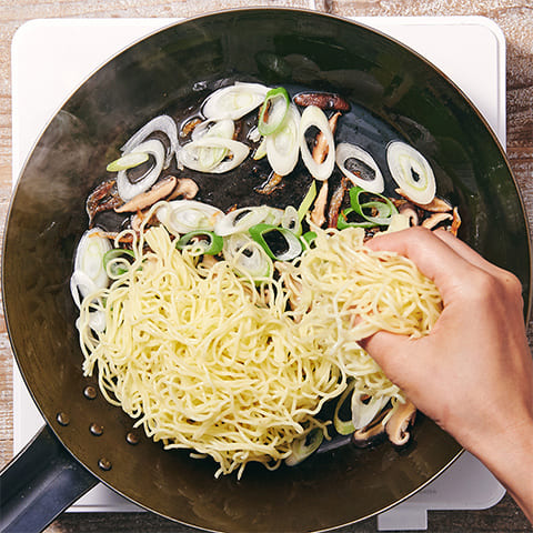 全体に油がまわったら蒸し麺を加える。