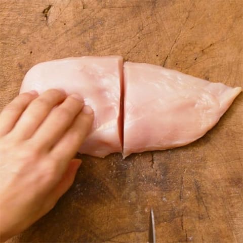鶏肉は半分に切り、それぞれ厚みのある箇所に包丁を入れて厚さを均一にし、こしょうをふる。