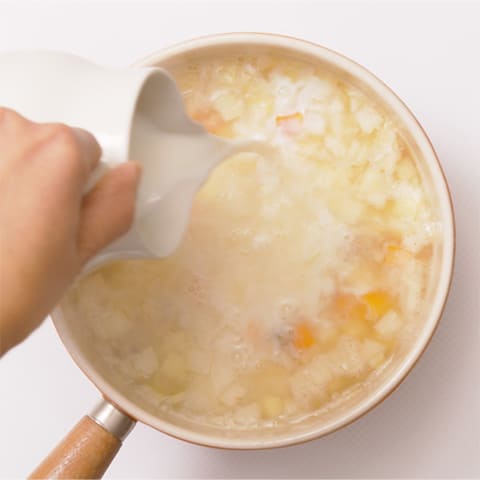 野菜がやわらかくなってきたら牛乳を加え、  こしょうで味を調える。